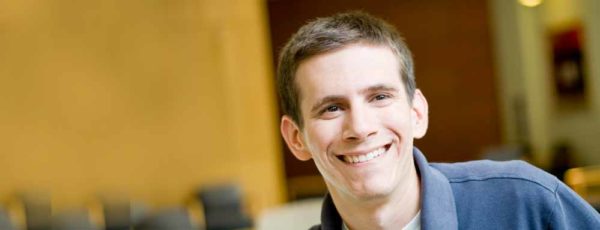 Headshot of Andrew Paciorek. He has short, brown hair and is wearing a blue polo shirt.